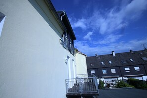 A residential building with a balcony, a window, and a clear blue sky. - a-domo Apartments Oberhausen - Studio Apartments & Flats - short or longterm - single or grouptravel (Oberhausen)