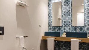 Ein modernes Badezimmer mit einem Bidet, einer Toilette und einem Waschtisch mit zwei Becken.
