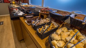Een buffet met diverse gerechten en brodenmanden.