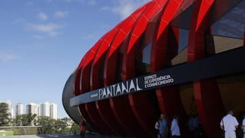 A modern building with a curved facade and a sign that reads "PANTANAL ESPAÇO DE EXPERIÊNCIA E CONHECIMENTO."