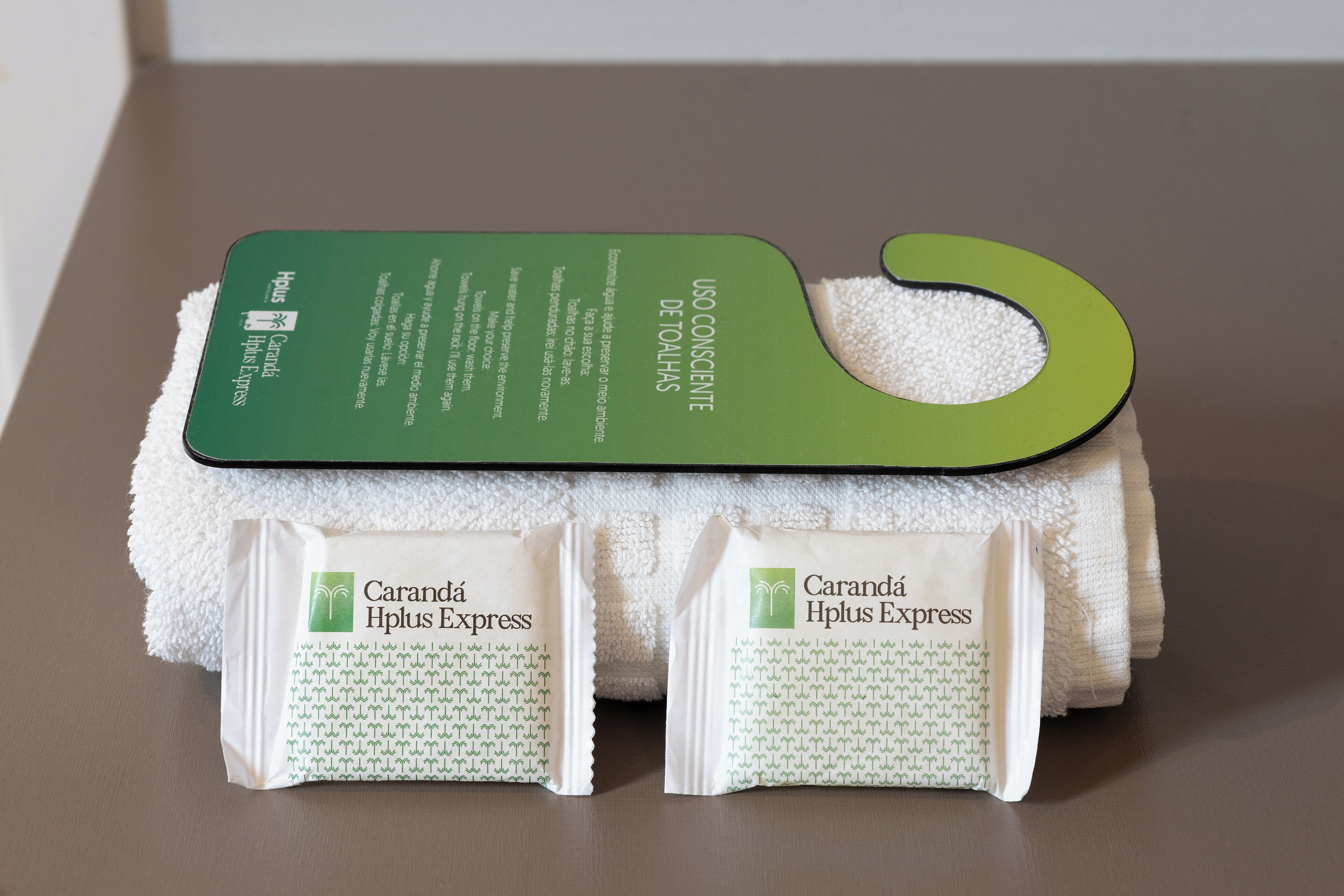 Een groene en witte handdoekenset met een hangende kaartje en twee verpakte producten met de aanduiding 