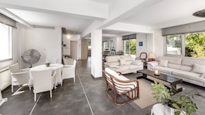 A spacious living area with a dining set, a sofa, and a coffee table. - Villa Hibiscus is a unique and spectacular four bedroom villa in an residential gated cul de sac (Protaras)
