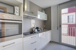 A modern kitchen with a built-in oven, a microwave, and a stainless steel range hood.