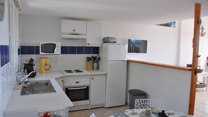 A compact kitchen with a microwave, stove, sink, and refrigerator. - Pavilion with terrace sea view and pool in residence (SAINT PIERRE LA MER)