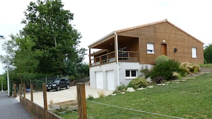A two-story house with a balcony, a garage, and a driveway. - MATHES la PALMYRE house WOOD (BBC label) (Les Mathes)