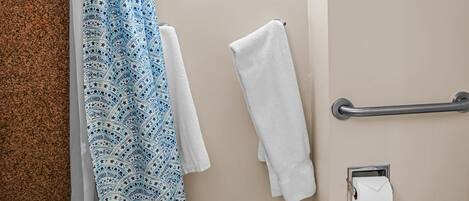 Bagno con vasca, servizi igienici, doccia con porta asciugamani e mancorrente.