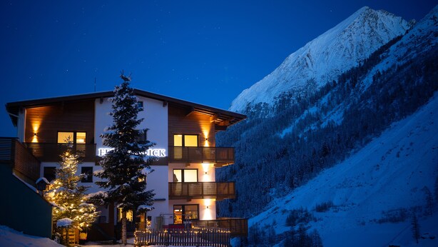 Un hôtel à plusieurs étages, doté d’un design moderne, situé dans une région montagneuse enneigée.