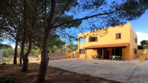 Un bâtiment jaune doté d’un patio carrelé et d’un espace extérieur aménagé pour s’asseoir.