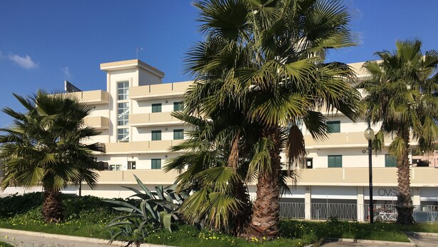 A multi-story hotel with a modern design, featuring balconies and a flat roof. - Appartamento Emma (Gallipoli)