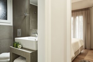 Een moderne badkamer met een groot wastafel, spiegel en toiletartikelen.