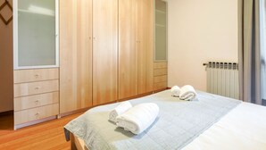 A bedroom with a bed, a wardrobe, a radiator, and a window with curtains. - Casa @rena - Pool - Patio - Pet friendly - LAKE (Sirmione)