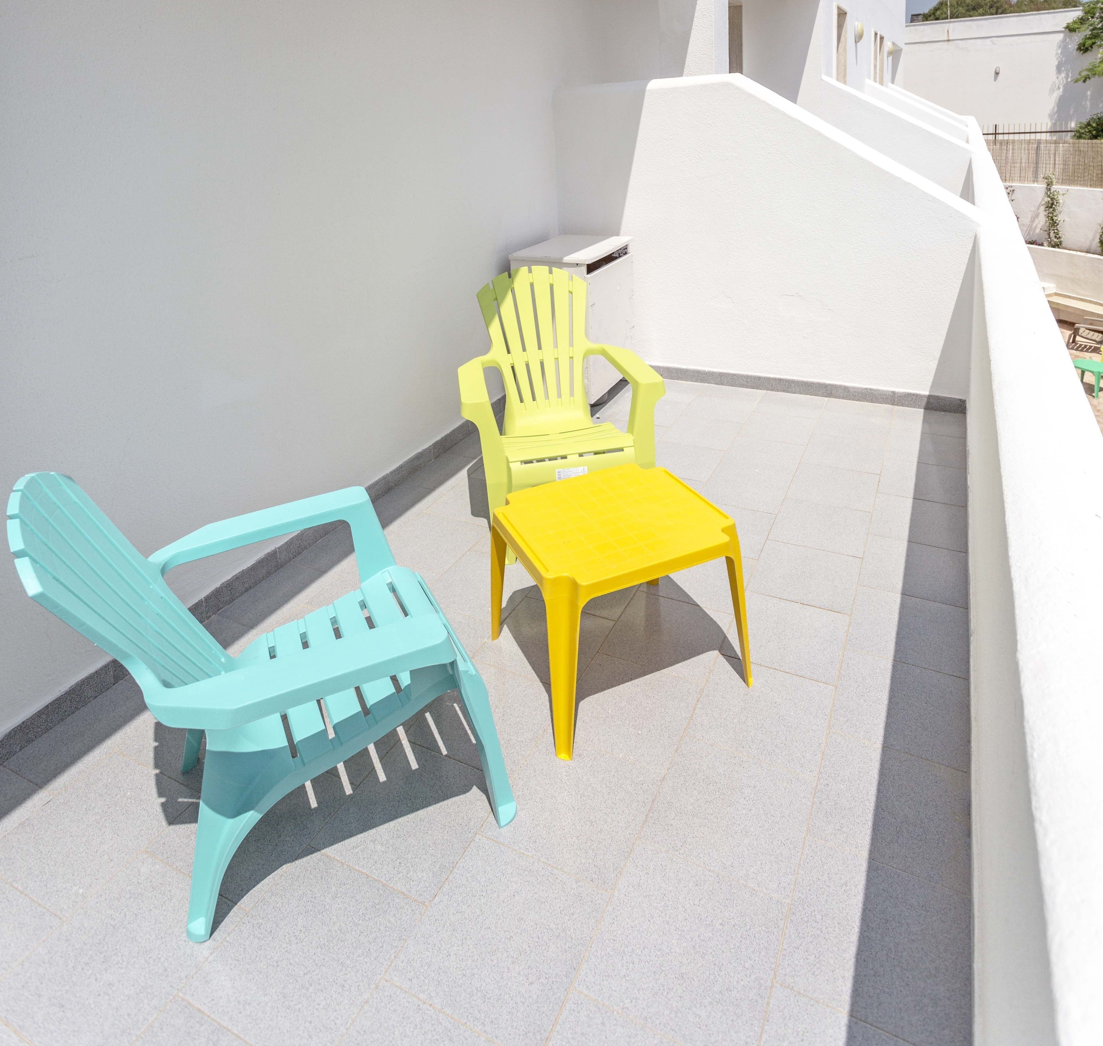 Un petit espace extérieur aménagé avec deux chaises et une table.