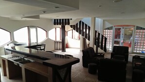 A spacious living area with a kitchen counter, dining table, and multiple seating options.