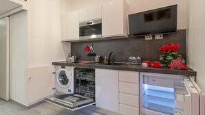A modern kitchen with built-in appliances, a washing machine, and a refrigerator. - notaMi - NotaMi Red Studio (Milan)