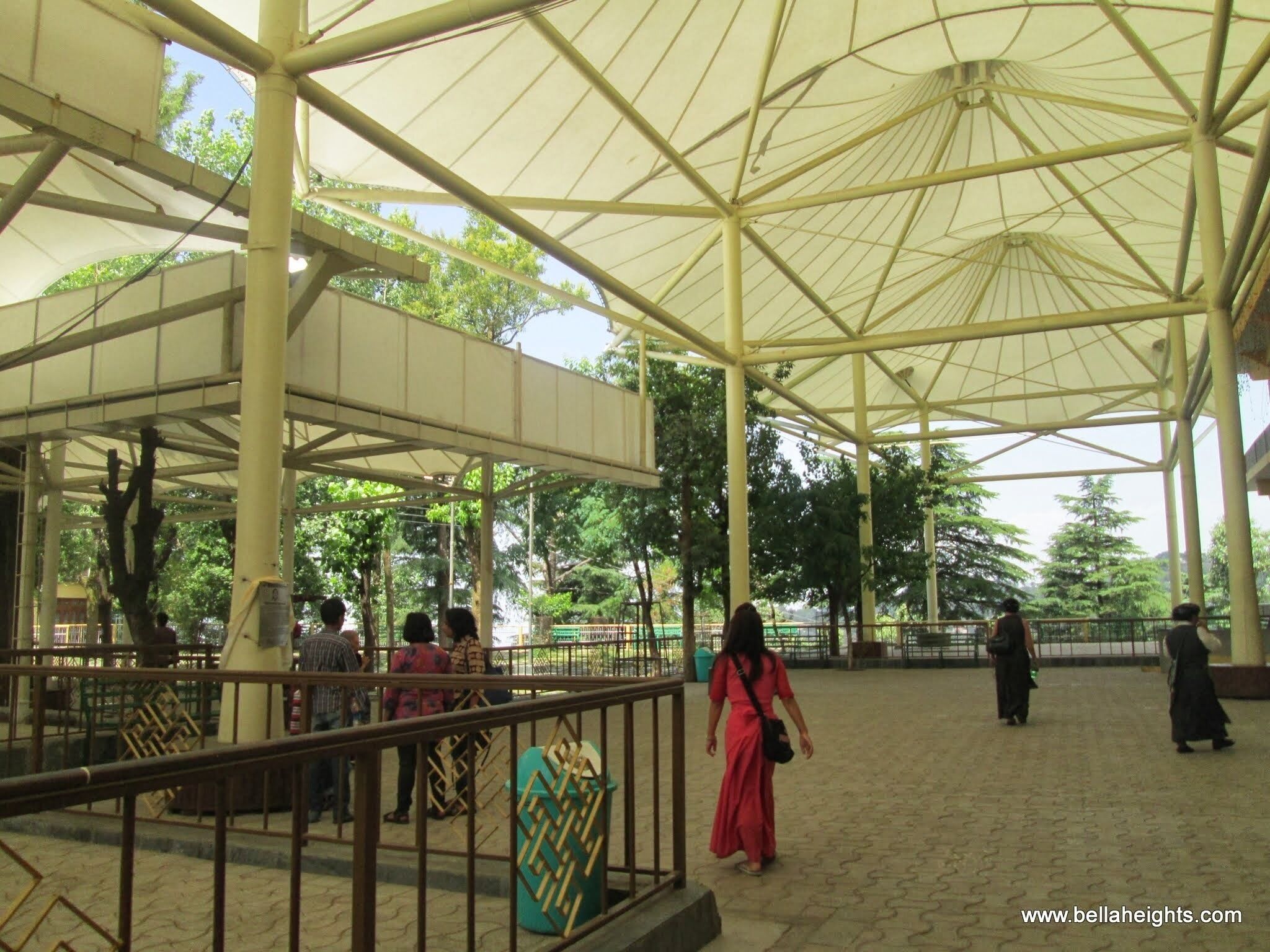 A covered pavilion with a tiled floor and metal railings.