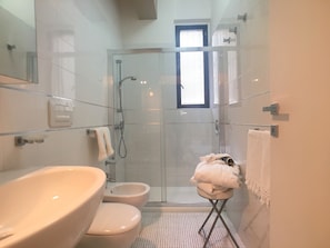 A bathroom with a glass-enclosed shower, a sink, and a toilet. - Appartamento Mon Amour (Gallipoli)