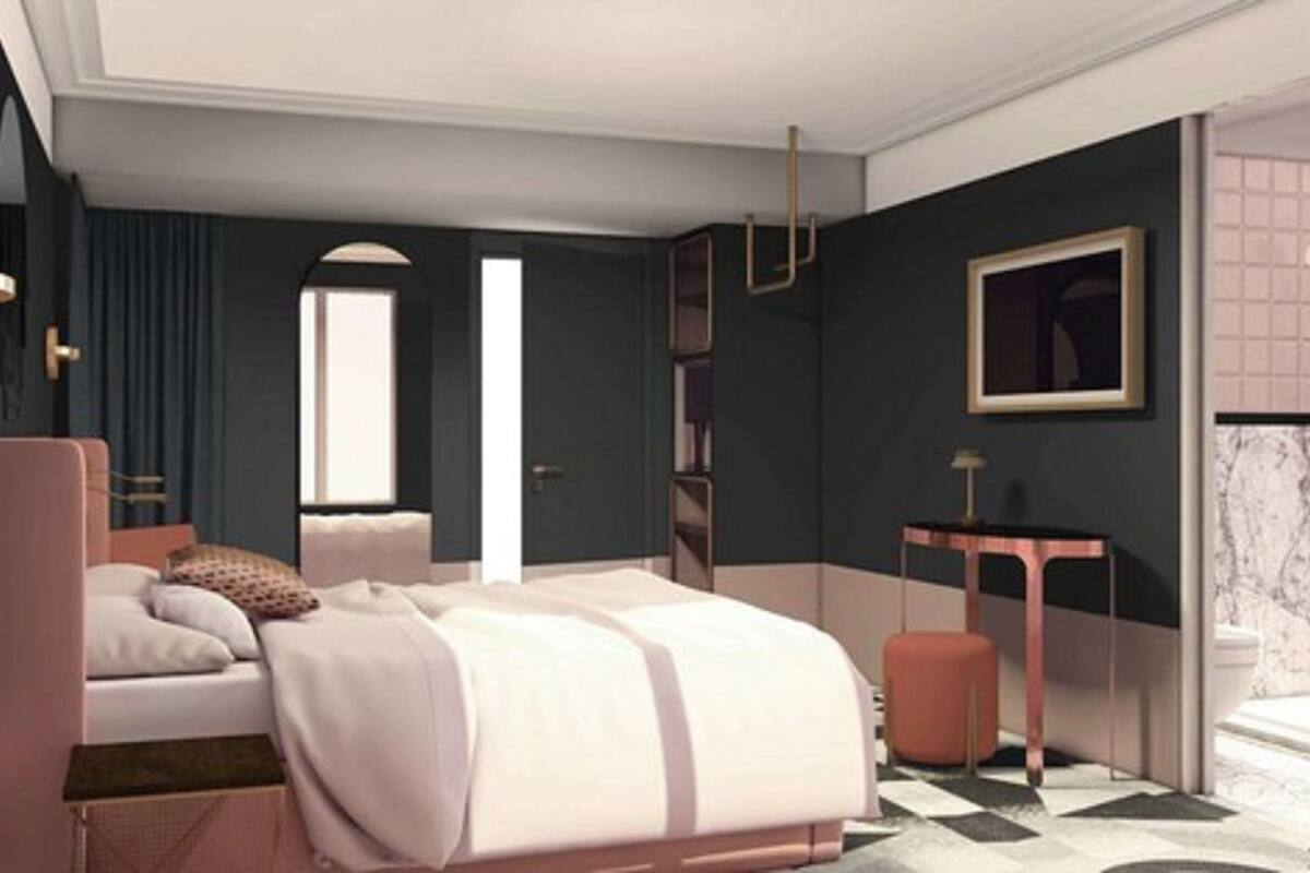 A modern bedroom with a large bed, bedside tables, a desk, and a chair.
