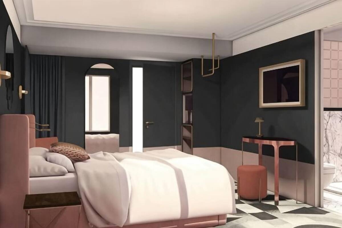 A bedroom with a bed, bedside table, and a window.