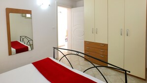 Ein Schlafzimmer mit einem Bett, einem Kleiderschrank, einem Spiegel und einer Treppe.