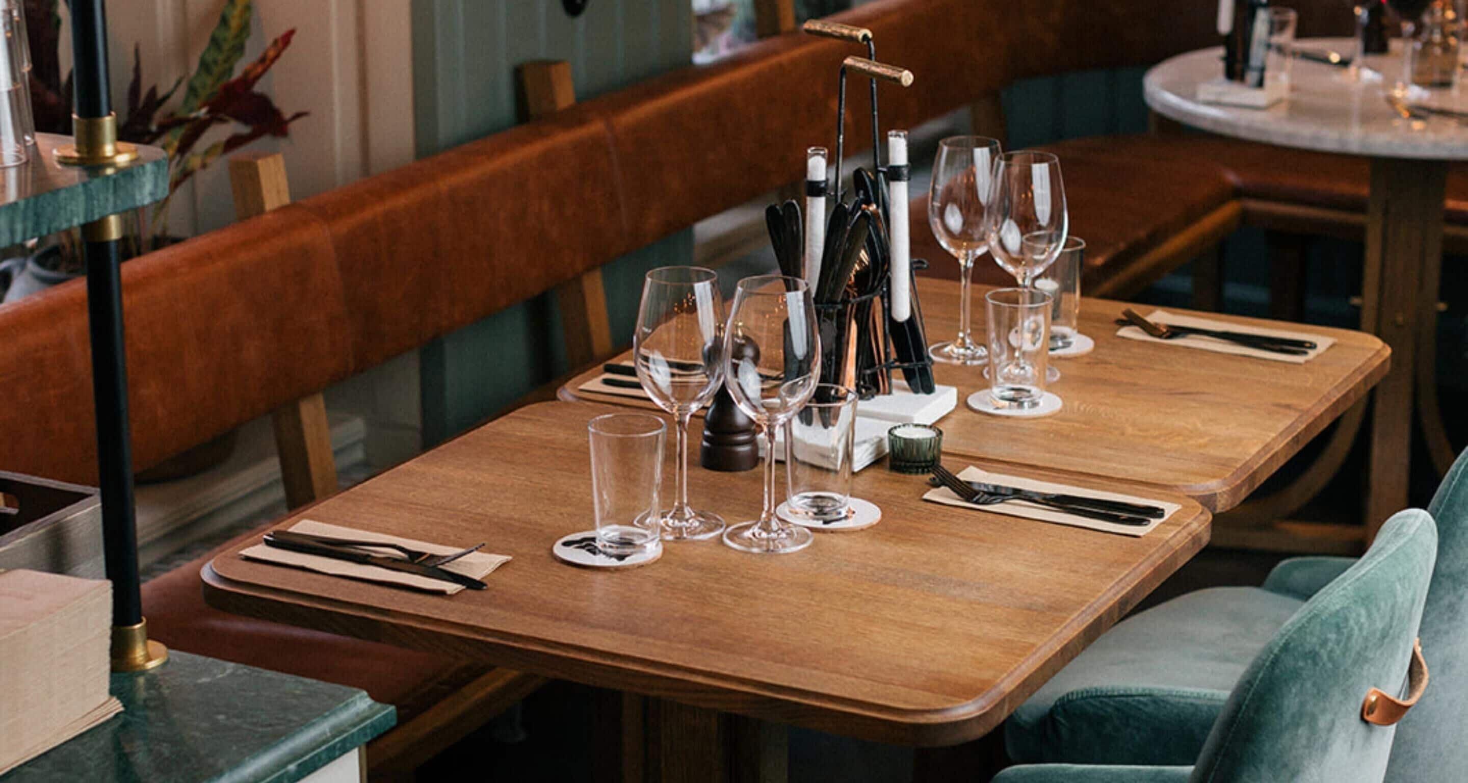 A restaurant table set with wine glasses, cutlery, and a menu.