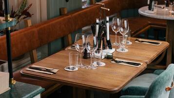 A restaurant table set with wine glasses, cutlery, and a menu.