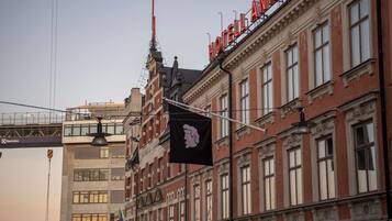 Un edificio histórico con un llamativo letrero rojo que dice "HOTEL AINO".