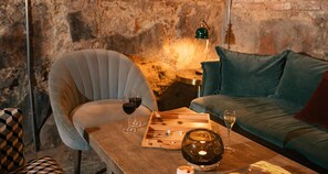A cozy room with a wooden table, a chair, a sofa, and a lamp. - Hotel Frantz, WorldHotels Crafted  (Stockholm)