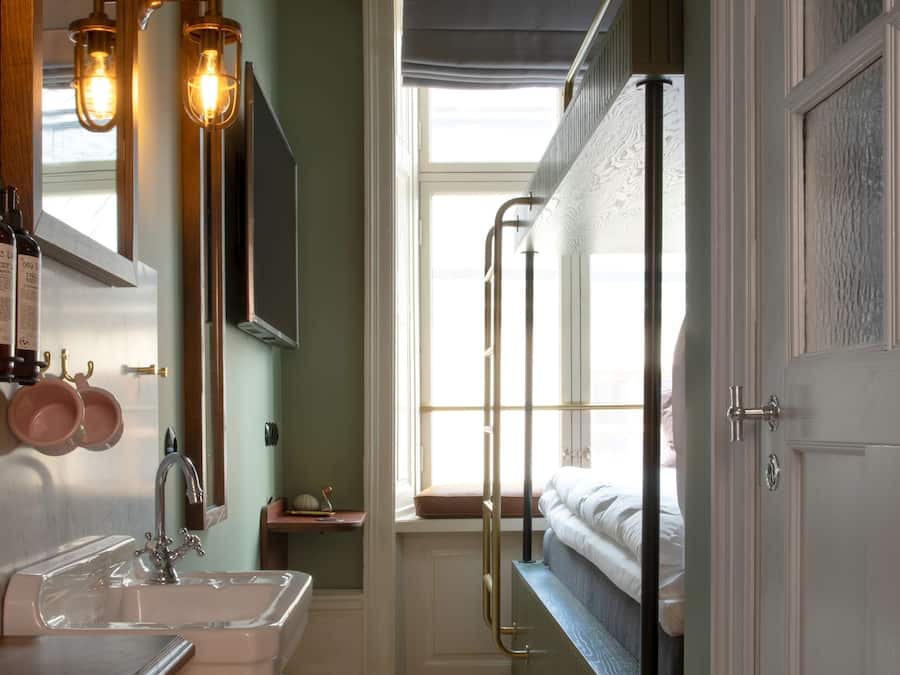 Une salle de bain avec un lavabo, un miroir et des luminaires suspendus.