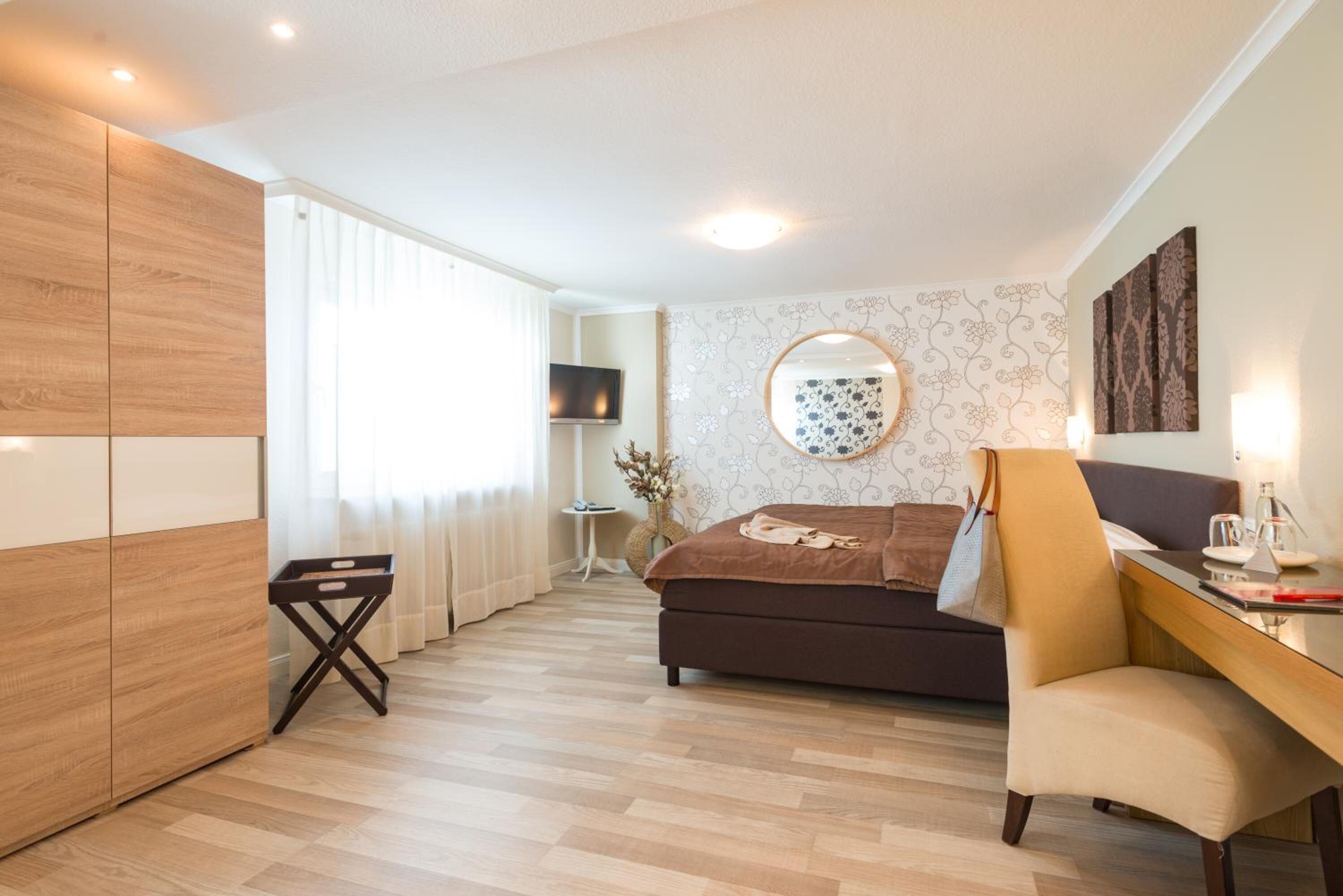 Un dormitorio moderno con cama, escritorio y televisión.