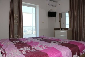 Relax in a spacious room with a large bed, flat-screen TV, and dresser.