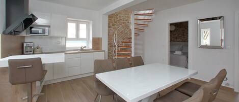 Eine moderne Küche mit weißer Arbeitsplatte, integriertem Mikrowellenherd und einer Wand mit Steinverkleidung.