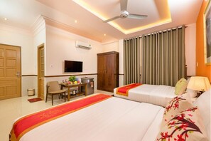 A hotel room with two beds, a desk with a chair, a television, and a wardrobe.