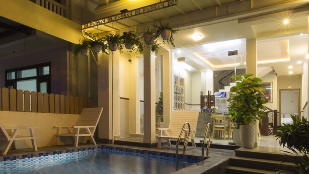 Un bâtiment à deux étages doté d’une piscine, d’un espace extérieur aménagé et d’un escalier menant à l’étage supérieur.