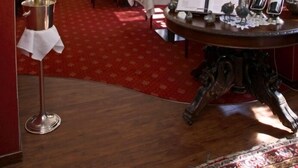 A dining area with tables set for service, a chandelier, and red curtains. - Hotel Saarburger Hof (Saarburg)