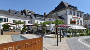 A hotel with outdoor seating and a sign reading "FRUCHTMARKT". - Hotel Saarburger Hof (Saarburg)