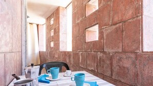 A dining area with a table set for two, featuring a striped tablecloth, blue napkins, and a mix of white and blue cups and saucers. - Appartamento White Fronte Mare (Gallipoli)