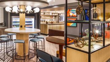 A modern bar area with a round table, bar stools, and a counter.