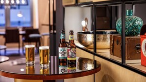 A bar area with a round table displaying beer bottles and glasses. - ibis budget Swindon Town Centre (Swindon)
