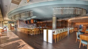 A spacious bar area with multiple seating arrangements and a modern design. - 110 South Hampton - Barefoot Resort Rentals (Myrtle Beach)