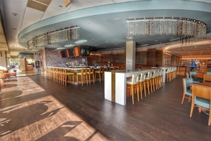 Eine großzügige Bar mit verschiedenen Sitzmöglichkeiten und modernem Design.
