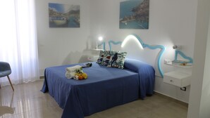 A neatly arranged bedroom with a bed, bedside tables, and artwork on the walls. - Exclusive Home (Castellammare del Golfo)