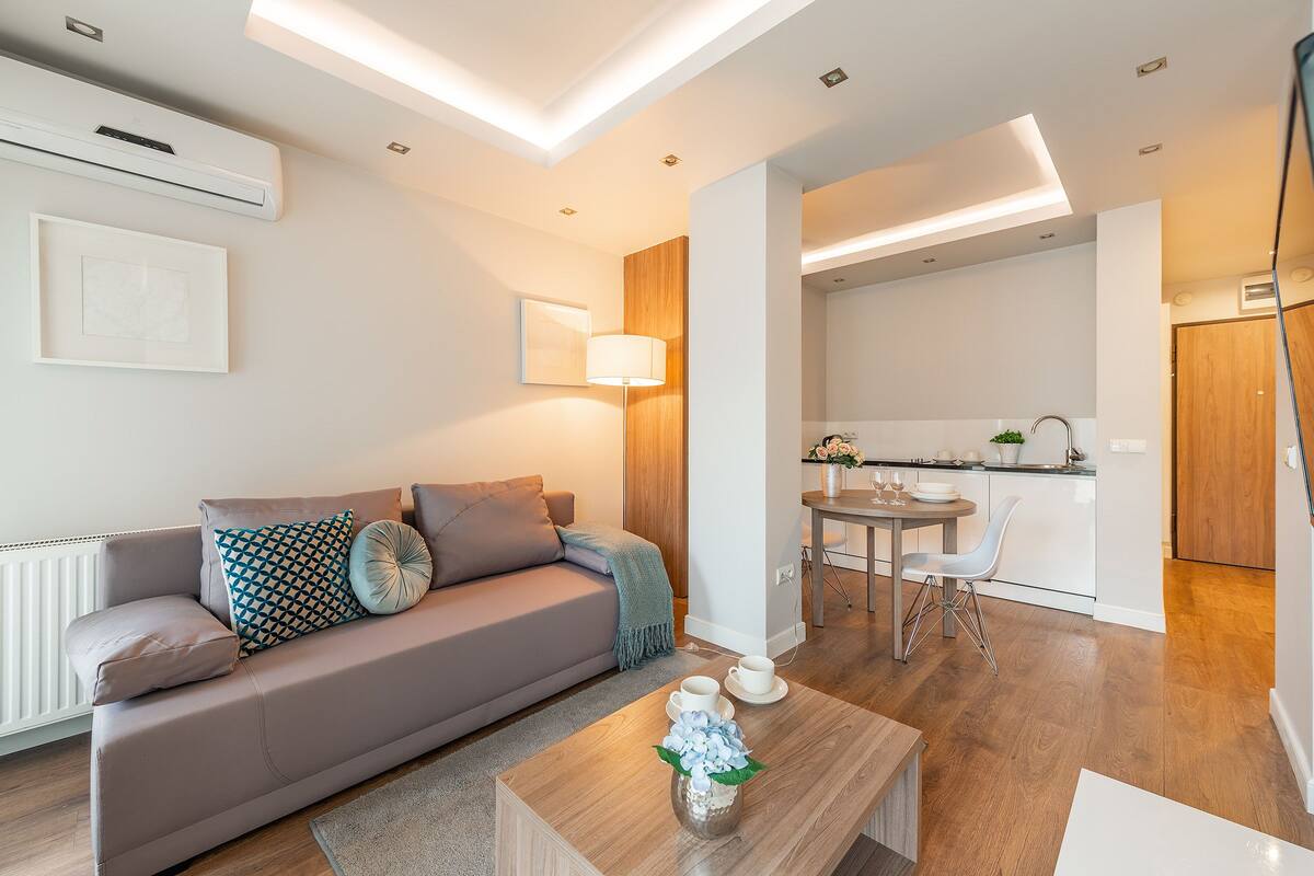 Ein modernes Wohnzimmer mit einer Couch, einem Couchtisch und einem Essbereich mit Tisch und Stühlen.