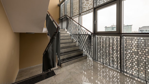 Eine moderne Treppe mit Metallgeländern und großen Fenstern.
