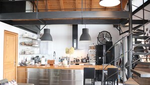 A modern kitchen with a central island, stainless steel appliances, and pendant lighting. - Skylark Bed & Breakfast (Grasse)