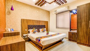 Una habitación de hotel con una cama grande, cabecera de madera y un armario empotrado.
