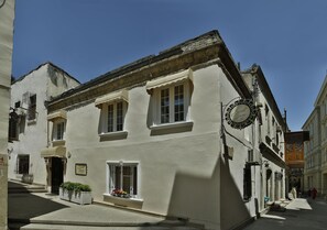 A narrow street with a building featuring a sign that reads "Hotel de la Poste."