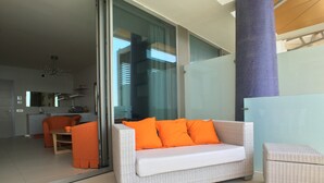 A modern living area with a white sofa, orange cushions, and a glass partition. - Bilocale Marina (Gallipoli)