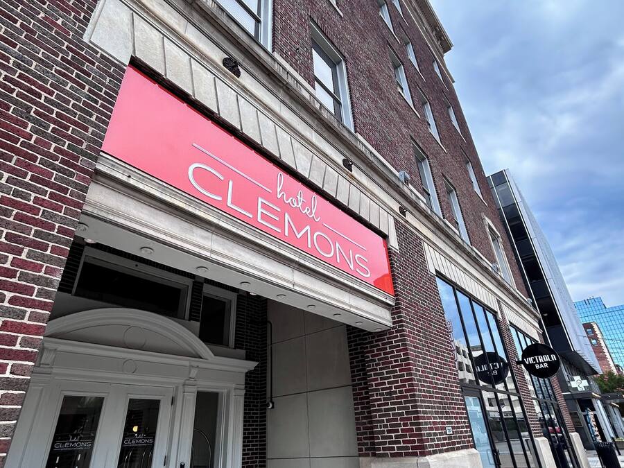 A hotel entrance with a red awning labeled "Clemons Hotel."