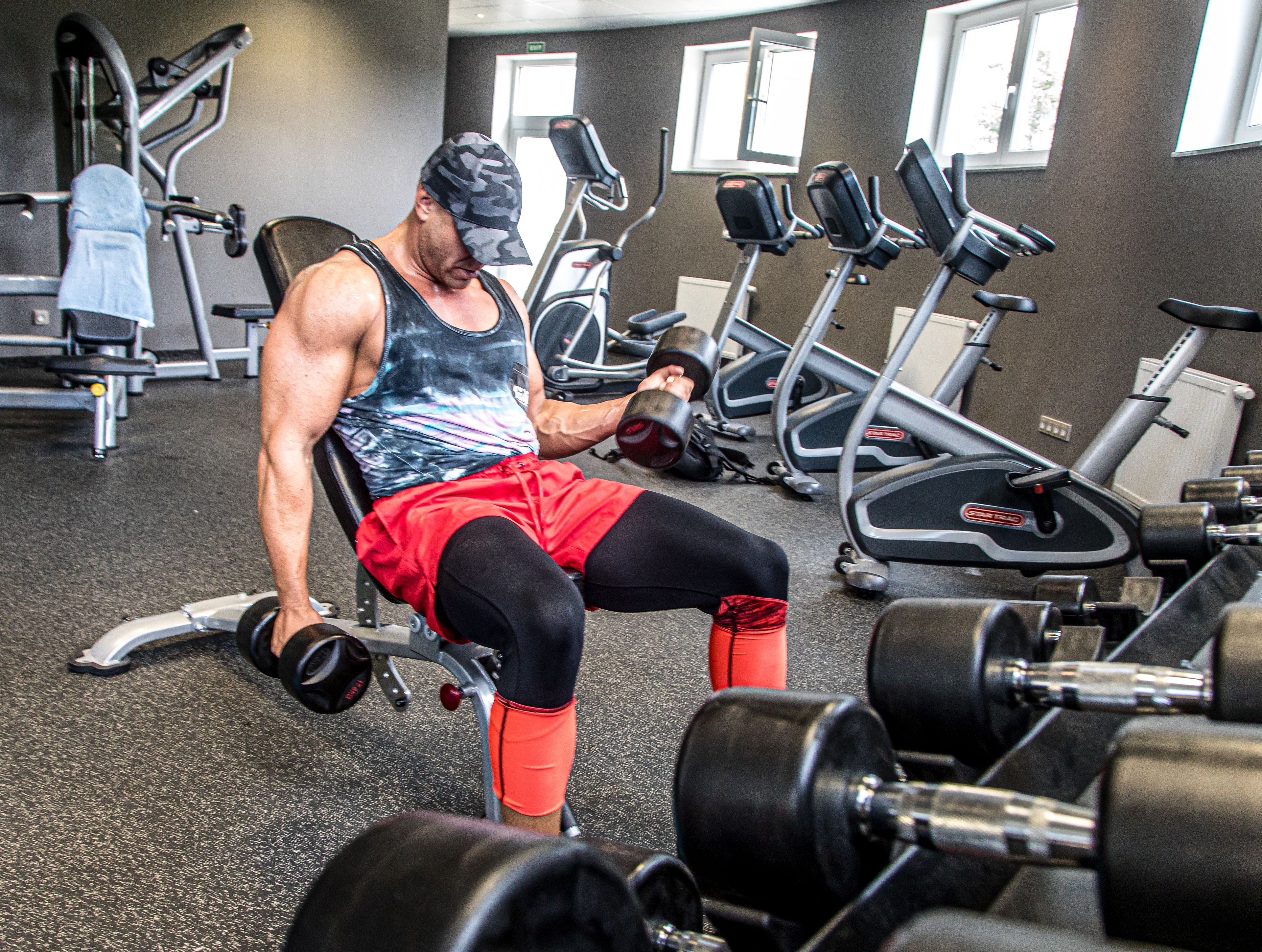 A gym with various exercise equipment, including dumbbells and treadmills.