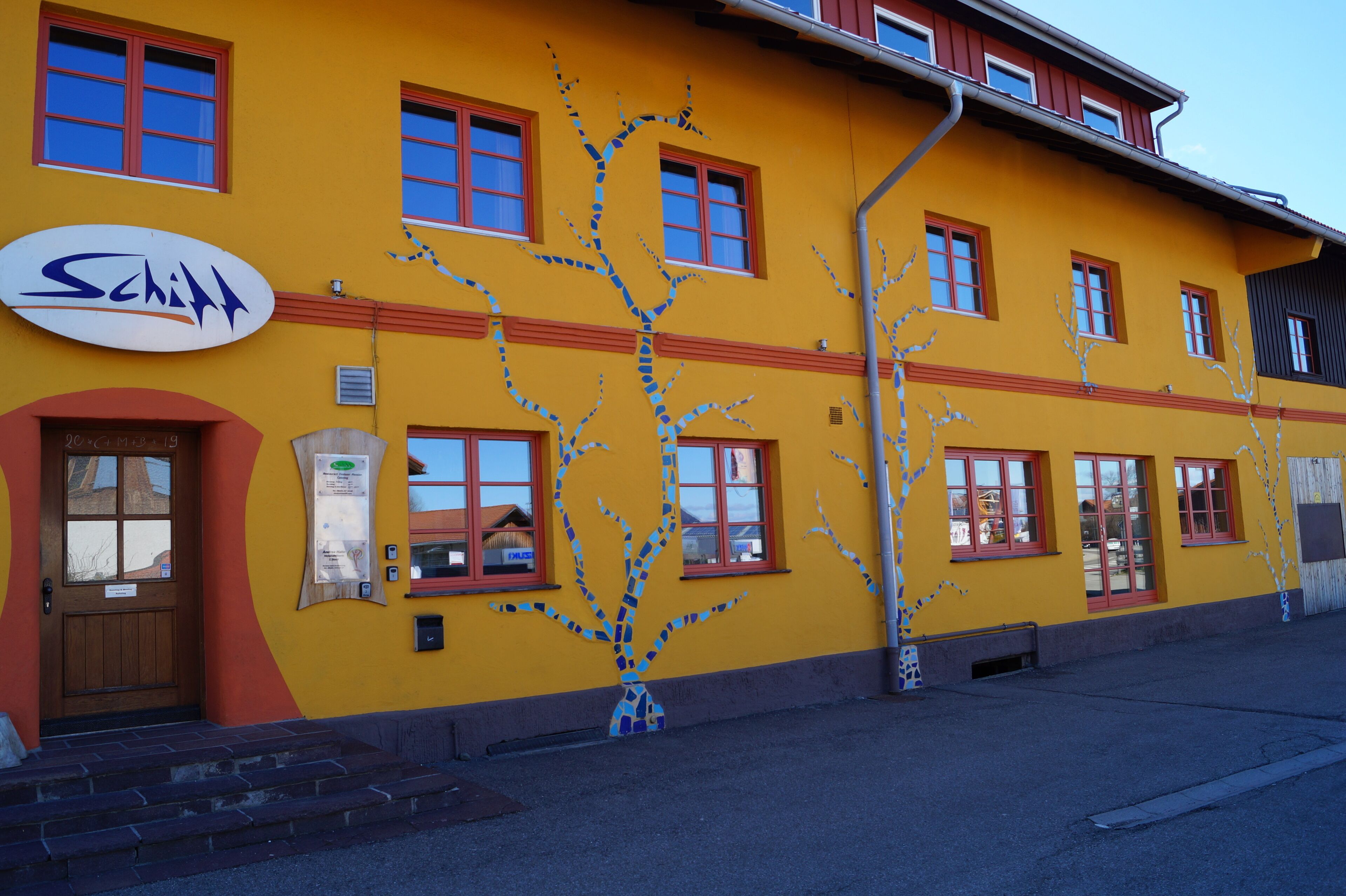 Un edificio amarillo con un cartel que dice "Schloss".
